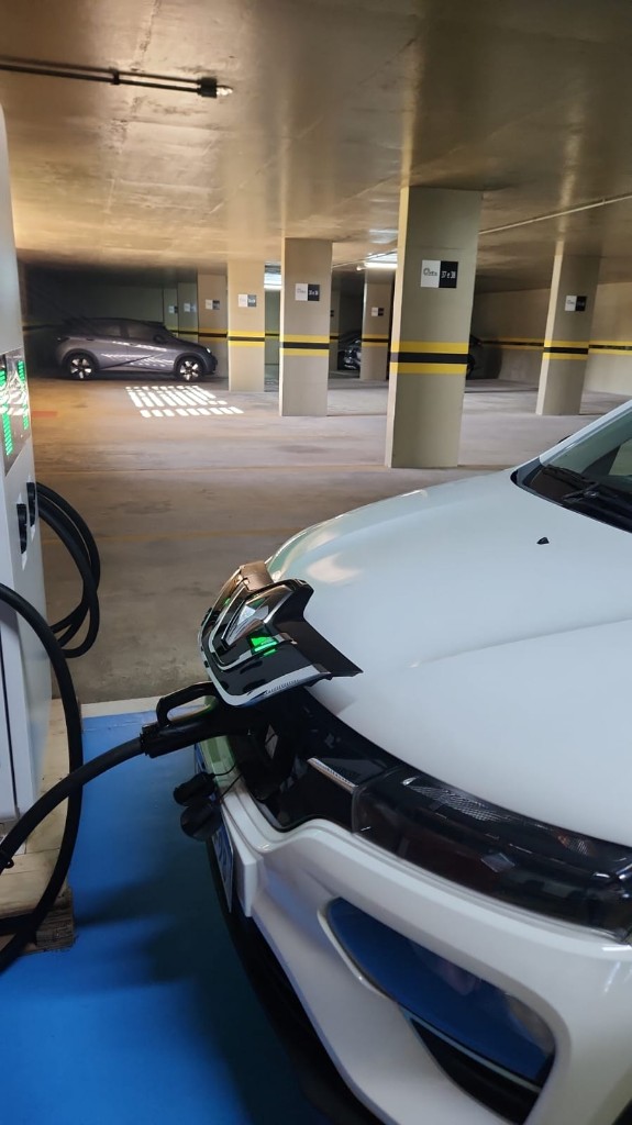 Carro elétrico recarregando em garagem de condomínio residencial